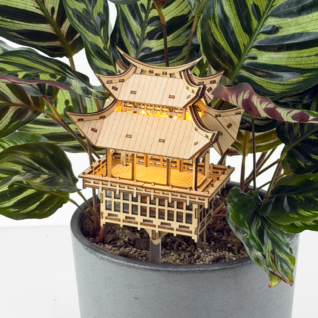 Tiny Treehouses 3D Puzzle Wooden Tiny Treehouse 3D Puzzles pagoda model in a potted plant with green leaves