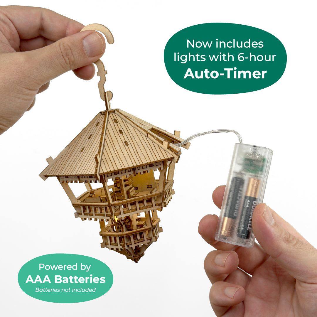 Tiny Treehouses 3D Puzzle Wooden model of a pagoda with a battery pack and text about auto-timer and AAA batteries.