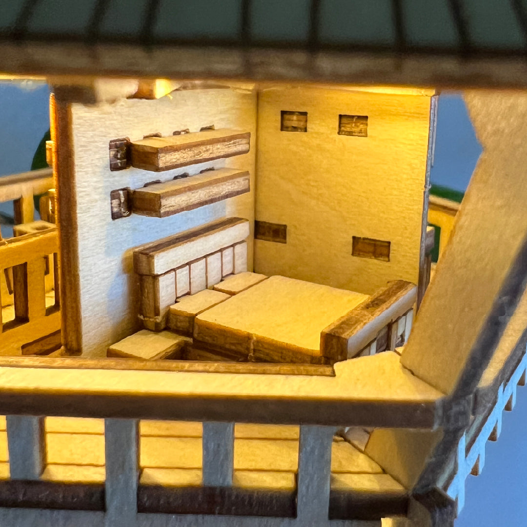Tiny Treehouses 3D Puzzle Model of the cabin interior with wooden furniture and deck.
