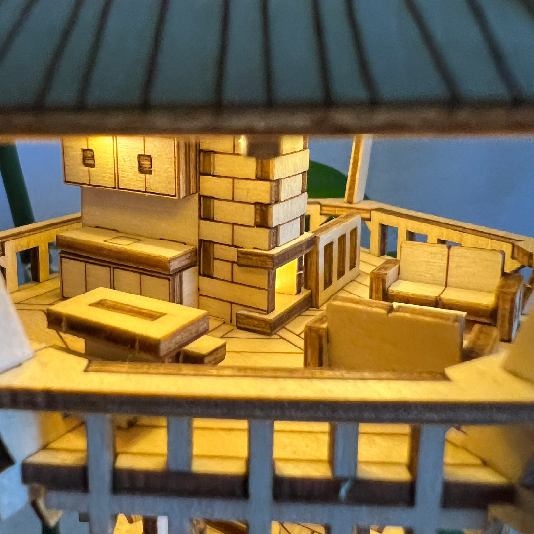 Tiny Treehouses 3D Puzzle Model of a wooden interior deck with furniture under a lamp