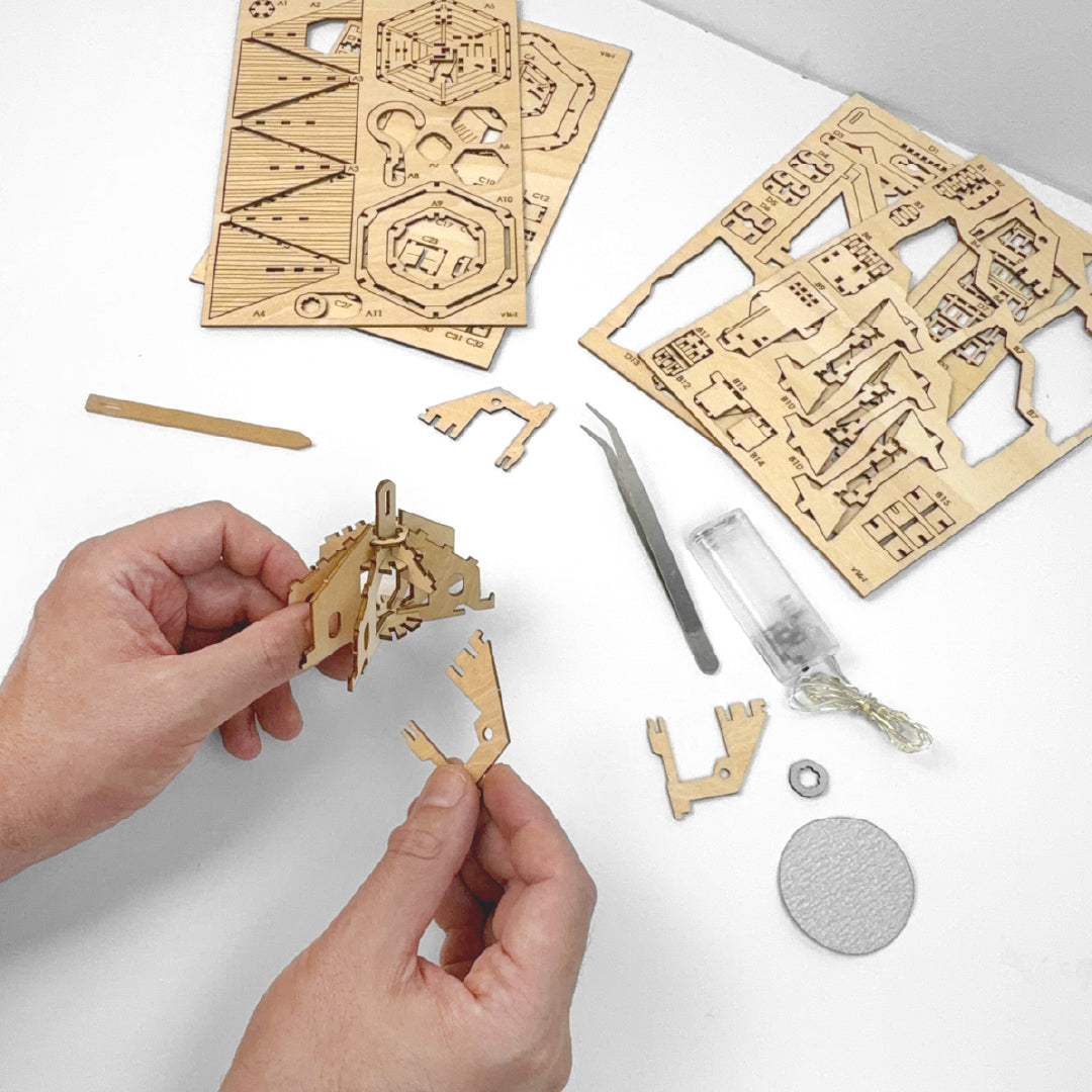 Tiny Treehouses 3D Puzzle Wooden puzzle pieces and tools on a white surface