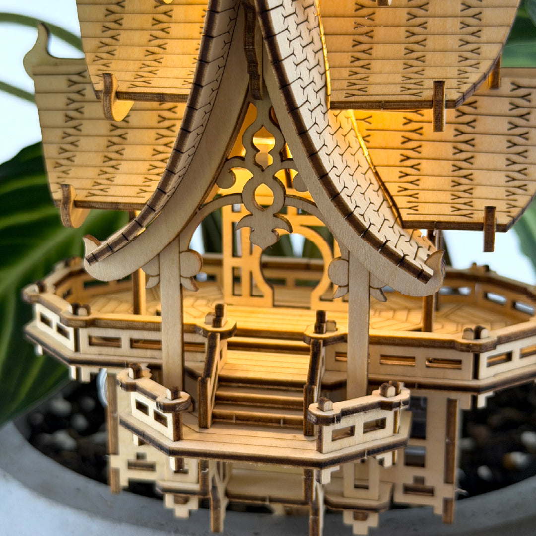 Tiny Treehouses 3D Puzzle Wooden model of a traditional Japanese temple Tiny Treehouse 3D Puzzle with intricate interior details, placed on a reflective surface.